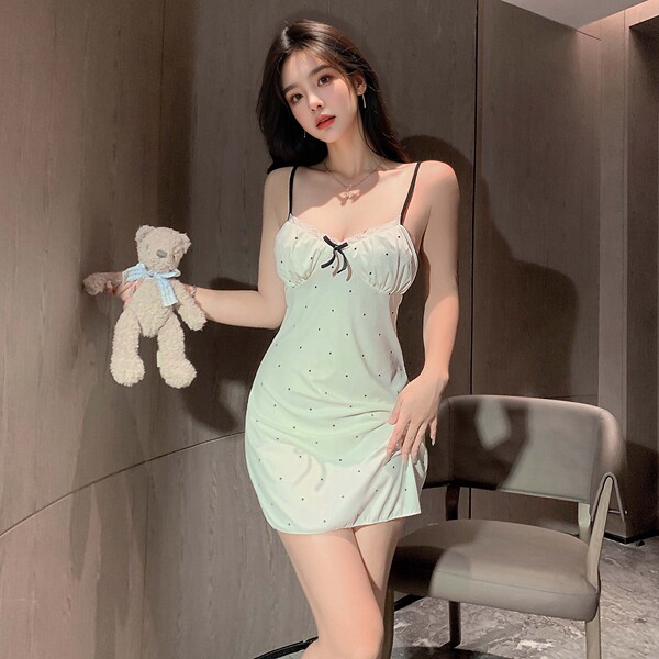 A woman poses with a teddy bear, wearing a light green lace sleepwear set featuring adjustable straps, a bow detail, and polk...