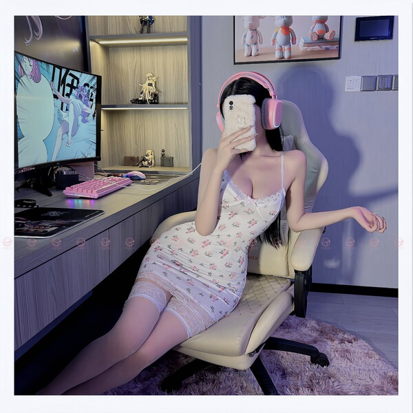 A woman lounges in a gaming chair wearing a floral lace contrast sexy low-cut slip dress made from pure temptation satin-blen...