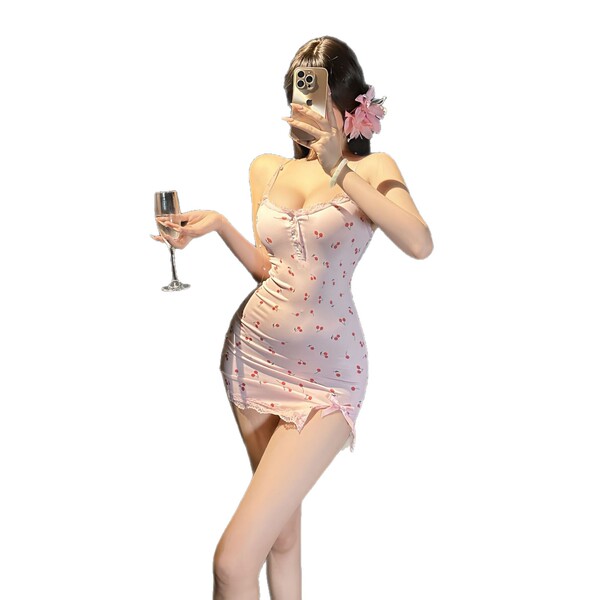 A woman poses with a champagne glass, wearing a sheer floral chemise adorned with cherry patterns, paired with a bodycon mini...