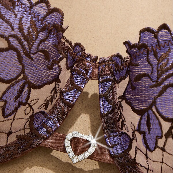 Close-up of french lace lingerie set with purple floral embroidery and crystal buckle detail on sheer mesh bra.