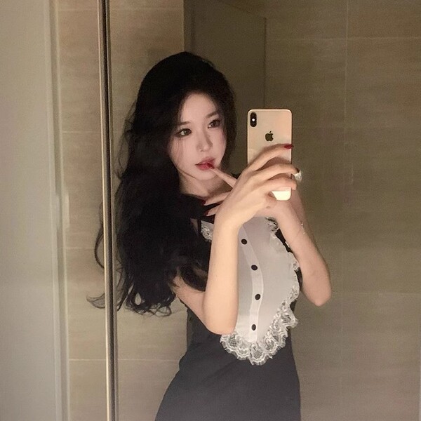 A woman takes a mirror selfie wearing a black gomeng lingerie set, featuring a catwoman bunny skirt with lace details and hea...