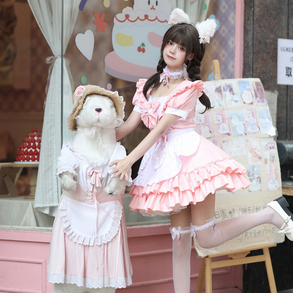 A person dressed as a maid in a cute pink uniform holds a matching plush rabbit doll, both featuring soft details and playful...