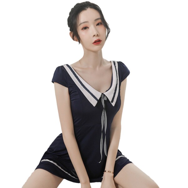 A woman wearing a navy blue japanese-style sailor uniform set, featuring a cute sailor collar, bow tie, and pleated skirt des...
