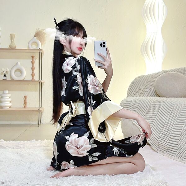 A woman poses while wearing a japanese kimono lingerie set, featuring a floral print and dramatic sleeves, capturing a flirty...