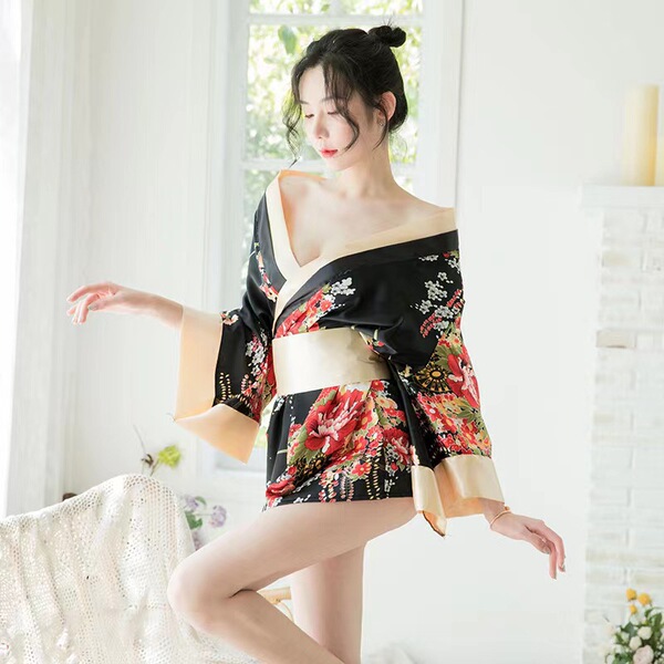 A woman poses elegantly in a floral japanese-style kimono, featuring a seductive design perfect for sleepwear or costume outf...