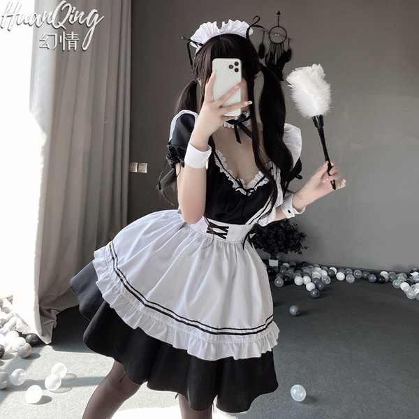 A woman poses in a japanese lolita maid costume set, featuring a black lace bodice and thigh-high stockings, holding a feathe...