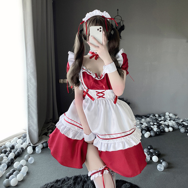 A person wearing a japanese maid costume, featuring a red and white lolita dress with ruffles and bows, perfect for cosplay o...