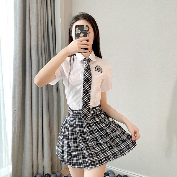 A person wearing a japanese school uniform, featuring a white blouse with a plaid tie and matching pleated skirt, perfect for...