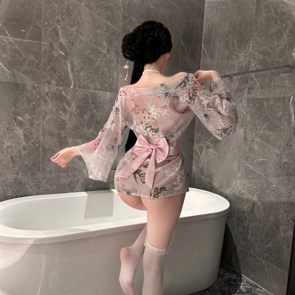 Woman wearing sheer floral japanese-style kimono lingerie set with open robe and matching bra brief in bathroom.