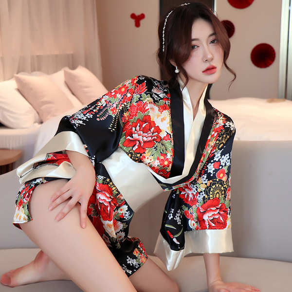 A woman poses elegantly in a japanese-style robe featuring vibrant floral patterns, sheer lace trim, and a low neckline, perf...