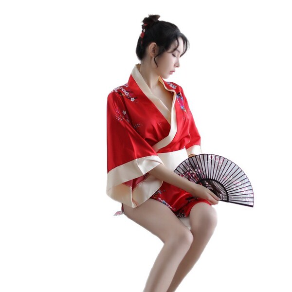A woman poses elegantly in a red japanese-style kimono with bow print, holding a traditional fan. the vibrant design features...