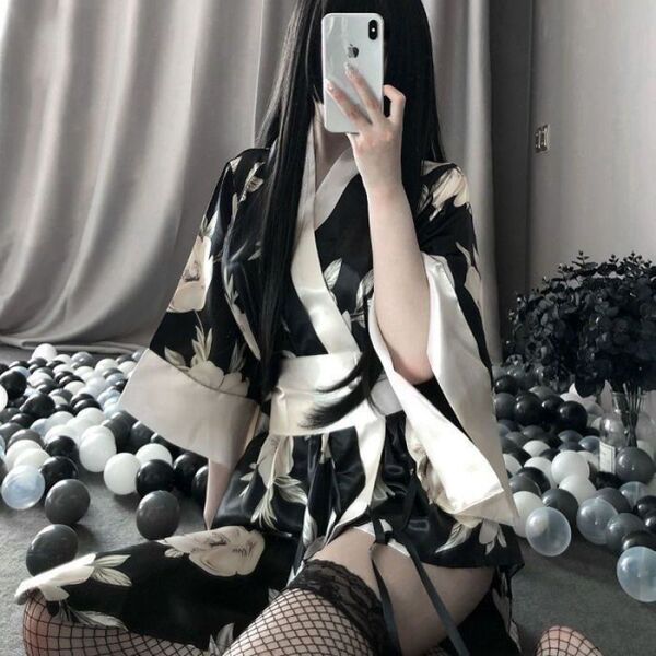 A woman poses in a japanese-style sleepwear set featuring a kimono-inspired nightgown and robe with a wrap design, adorned wi...