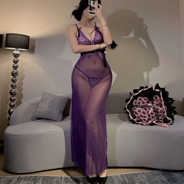 A woman poses in a sheer purple lace dress, highlighting its elegant design and see-through fabric. the bodice features delic...