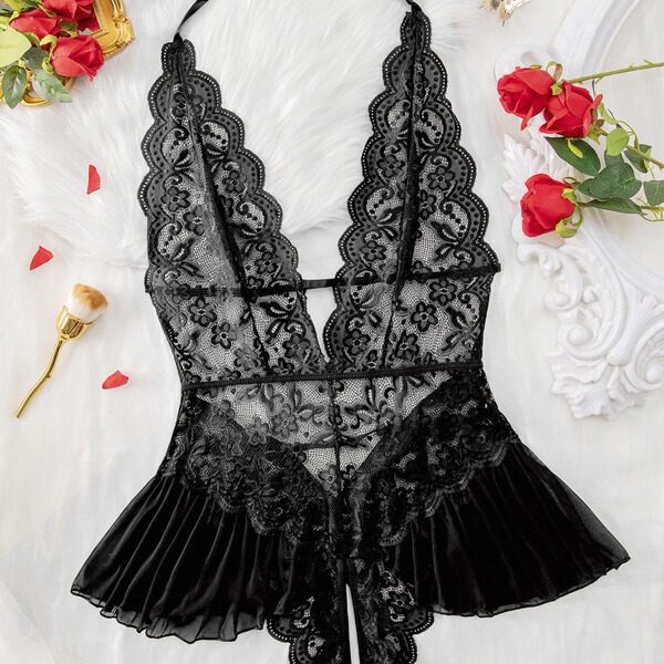 Luxury black lace bodysuit with sheer panels and scalloped edges, styled on white fur with red roses.