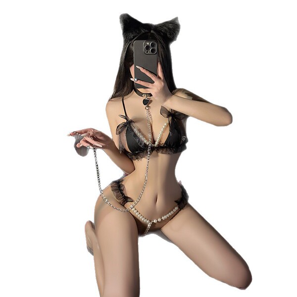 Woman wearing black lace three-piece pearl lingerie set with open-crotch design and cat ears, posing seductively while holdin...