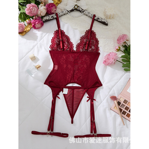Red lace cami set with garters, elegant erotic bodysuit for women, surrounded by flowers and makeup.