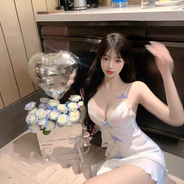 Woman in white lace sheer sleep dress with blue bows, posing beside heart balloon and roses. pure & tempting summer babydoll ...