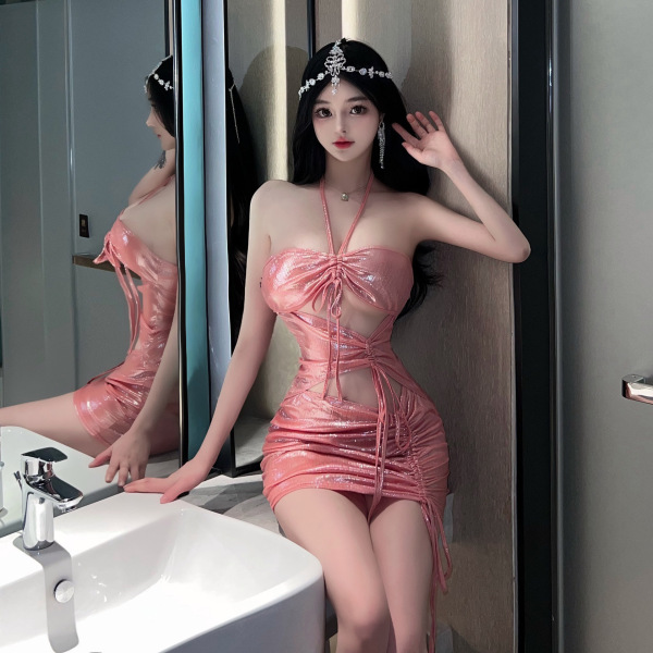 Woman wearing shiny pink liruru pvc halter mini dress with cut-outs, posing in bathroom.