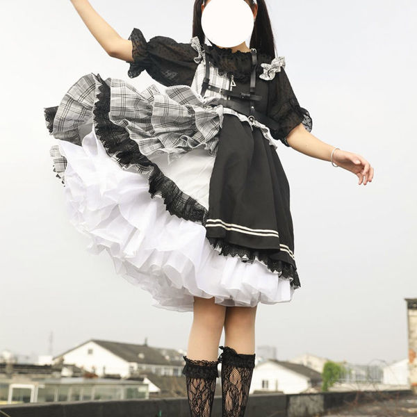 A person wearing a lolita-style dress featuring a crinoline petticoat, black lace details, and a voluminous skirt perfect for...