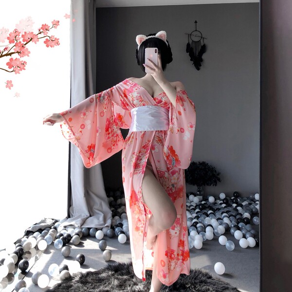 A woman poses in a japanese kimono-style lingerie set, featuring long sleeves and floral patterns, perfect for seductive nigh...
