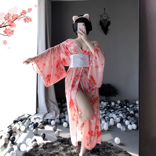 A woman poses in a pink floral japanese kimono-style cat girl lingerie set, featuring elegant long sheer sleepwear with cat e...