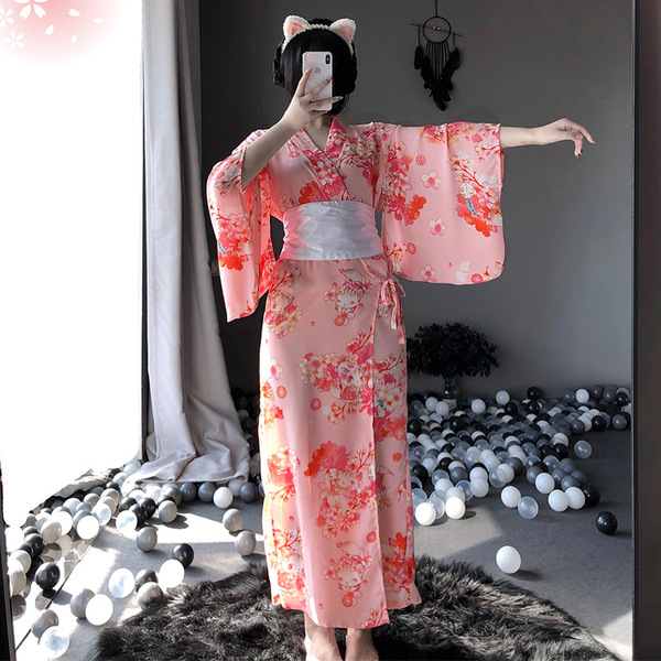 A woman models a pink floral japanese kimono-style cat-themed sleepwear set, featuring long sheer fabric and elegant design, ...