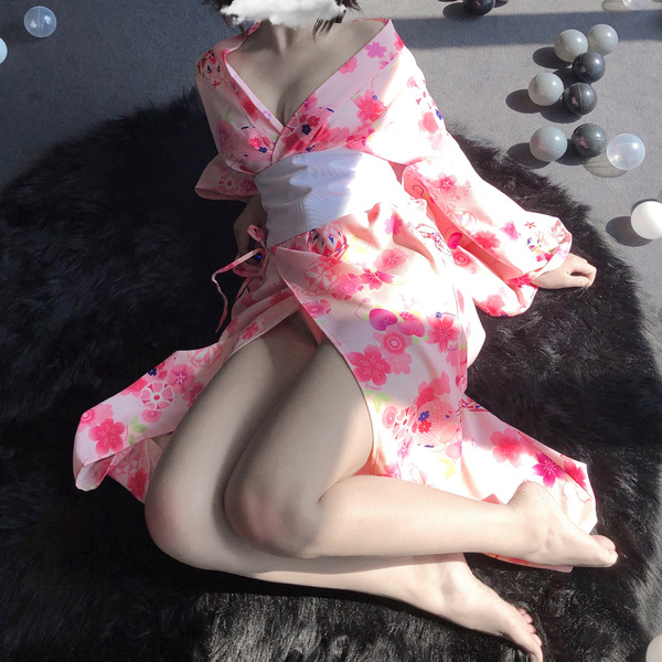 A person wearing a pink floral japanese-style kimono, ideal for role play and cosplay, lies on a black fur rug surrounded by ...
