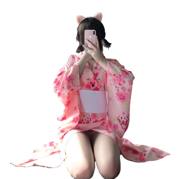 A person wearing a pink floral japanese-style kimono with cat ears, holding a phone to take a selfie. the outfit features pla...