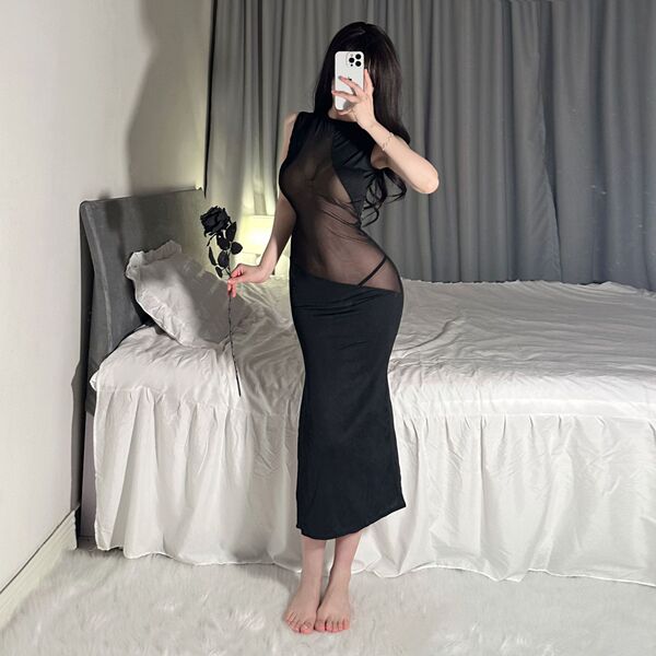 Woman in black sheer bodycon dress with lace mesh, holding a rose by bed – sexy nightclub party dress.
