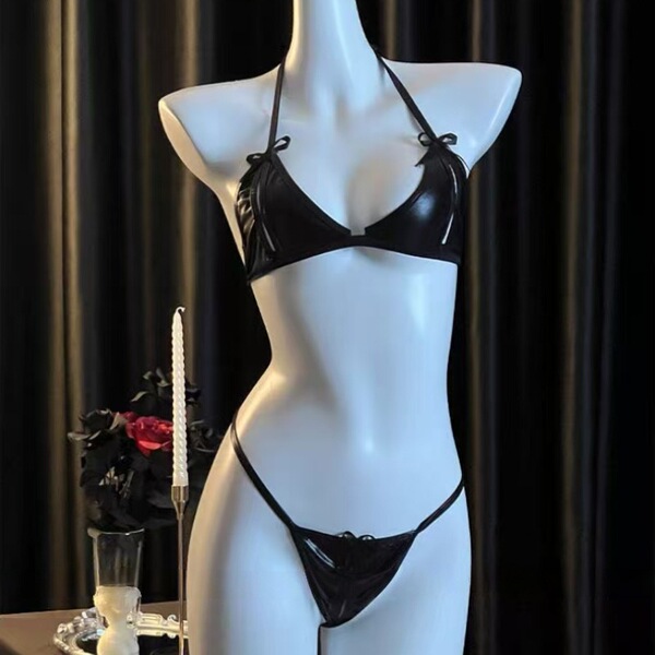 Black sheer lingerie-style bikini set on mannequin, featuring triangle top with ties and matching thong bottom, displayed aga...