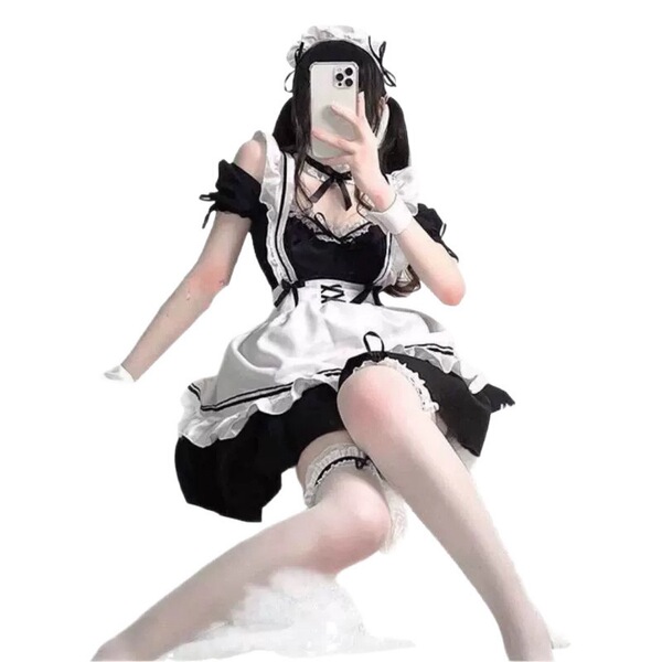 A woman poses in a black and white maid cosplay dress, featuring ruffles and lace details, perfect for lolita-style outfits.