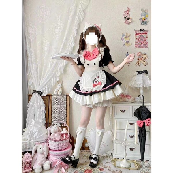 A woman models a maid costume cosplay dress, featuring a black and white outfit with a pink bow, lace details, and a petticoa...