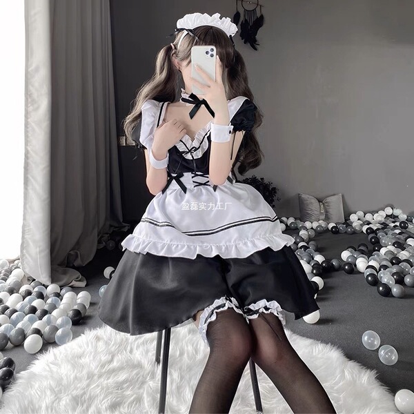 A woman wearing a maid costume cosplay dress, featuring a black and white outfit with ruffles, perfect for anime enthusiasts ...