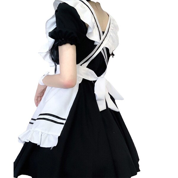 A woman wearing a maid costume, featuring a black and white dress with ruffles and a sailor-style collar, perfect for cosplay...