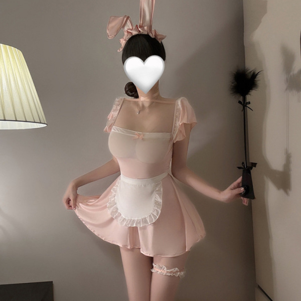 Woman modeling pink maid costume with bunny ears, sheer lace top, ruffled apron, and garter — sexy role play lingerie set.