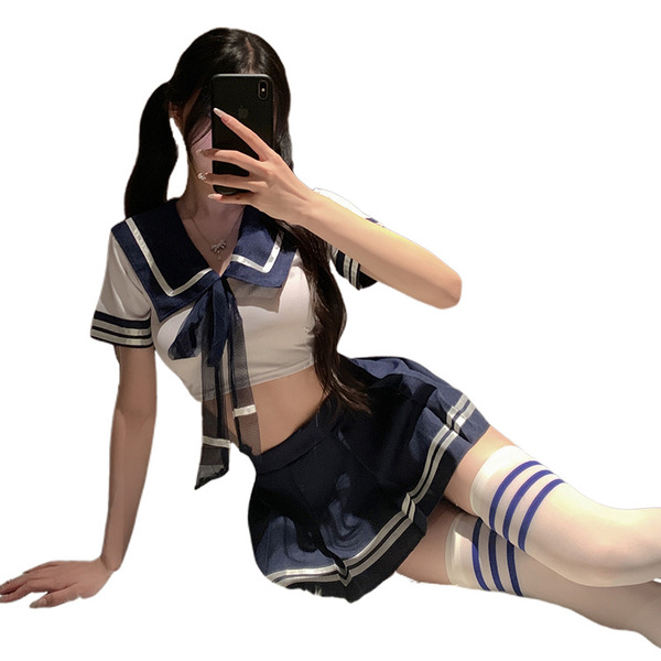A person wearing a cute schoolgirl outfit, featuring a sailor-style top with a bow tie and a pleated skirt, paired with strip...
