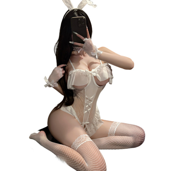 Woman in white sheer mesh bunny lingerie set with underwire push-up bodysuit, lace trim, fishnet stockings, and bow headband.