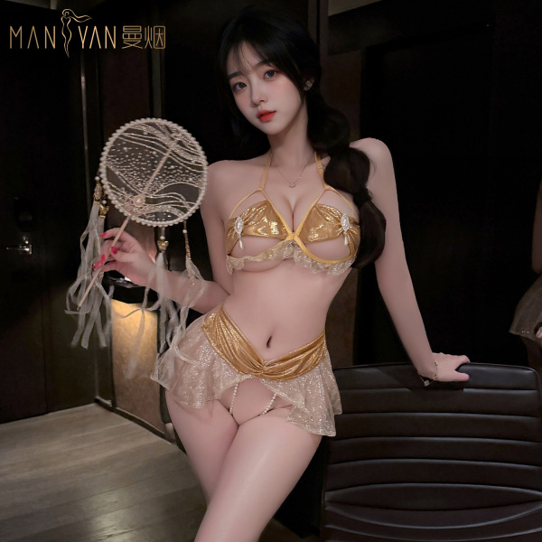 Woman wearing gold mannyan starlight dancer lingerie set with pearls, holding decorative fan. seductive open-crotch design fo...