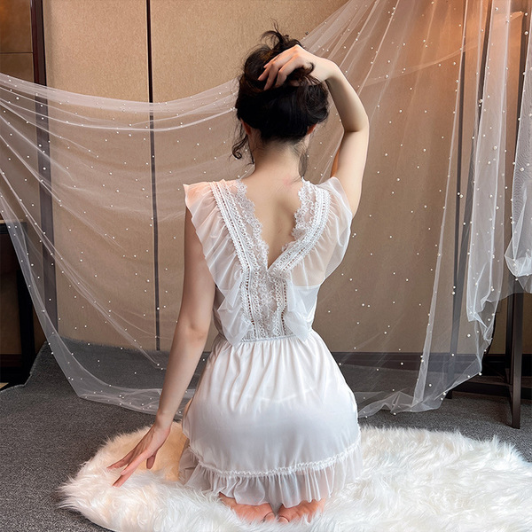 A woman sits on a fluffy rug, wearing a white mannyqing lace low-cut chemise sleep set made from ice silk. the outfit feature...