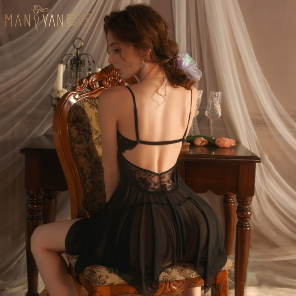 Woman wearing manyan sheer lace sleep dress with adjustable straps, seated in elegant room with soft lighting.