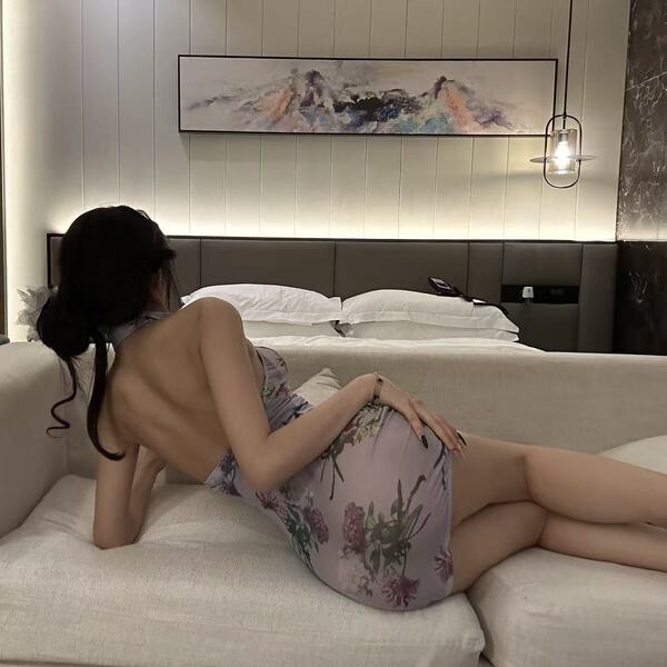 A woman lounges on a couch wearing a floral-patterned mi zhi lian sensual lingerie set, featuring a modest yet alluring desig...