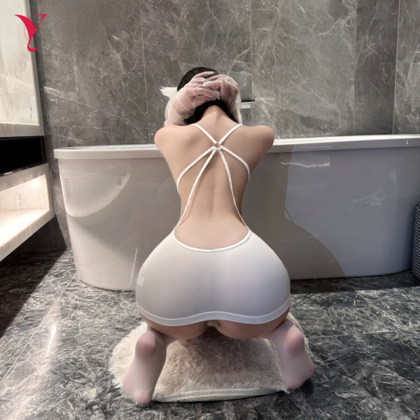 Woman in white night-ser lingerie set kneeling by bathtub, showcasing seductive backless design for passionate nights.