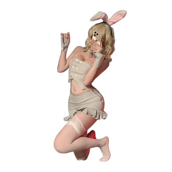 Woman in beige night-silk bunny girl lingerie set with ears, gloves, and thigh-highs, posing playfully while holding a phone.
