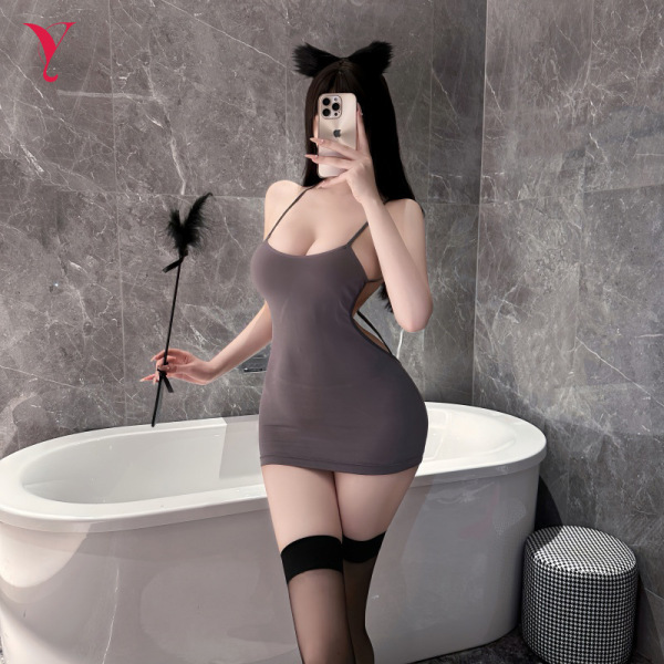 Woman in gray lace-back sleepwear set with cat ears, holding feather wand, posing by bathtub for romantic night.