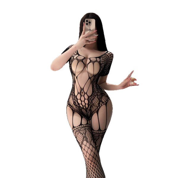 Woman wearing black nightsi mesh bodysuit with sheer lace, open crotch, and thigh-high stockings, taking a mirror selfie.