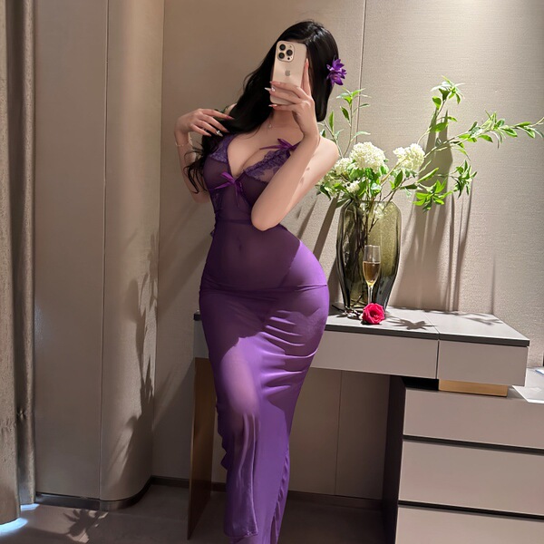 Woman in purple nightsigh nightseduce lingerie set, sheer sleepwear with floral detail, posing by vanity with flowers and win...