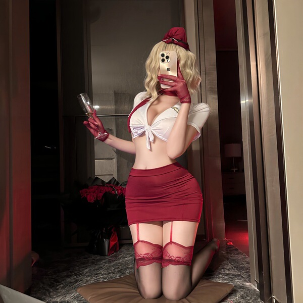 Woman in red nightsigh nightsere sexy lingerie dress with white top, posing with phone and champagne glass.