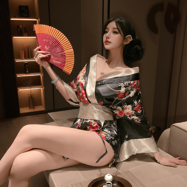 A woman elegantly poses wearing a japanese geisha-inspired sleepwear set, featuring a floral-patterned kimono robe with a red...