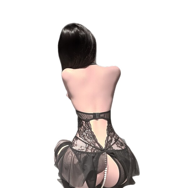 A woman wearing a black lace halter bra and sheer panty set, featuring intricate designs and a delicate bow detail, perfect f...