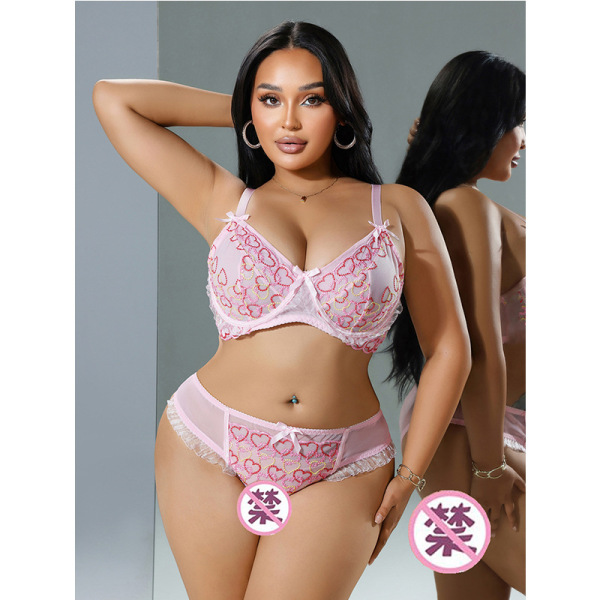 Woman modeling pink romantic lace lingerie set with floral sheer details, featuring a bra and panties for date night.